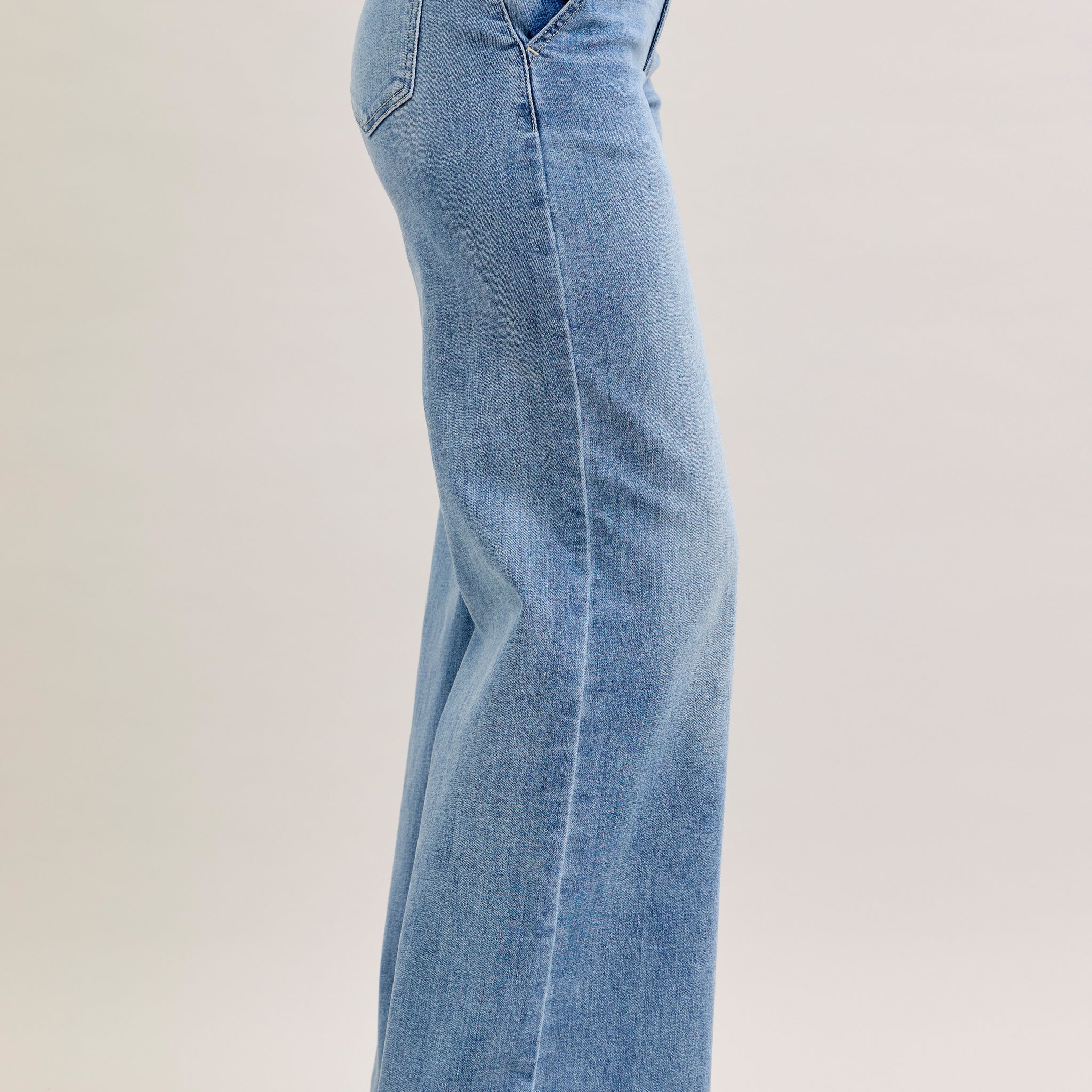 Light blue jeans worn by a person on a plain background