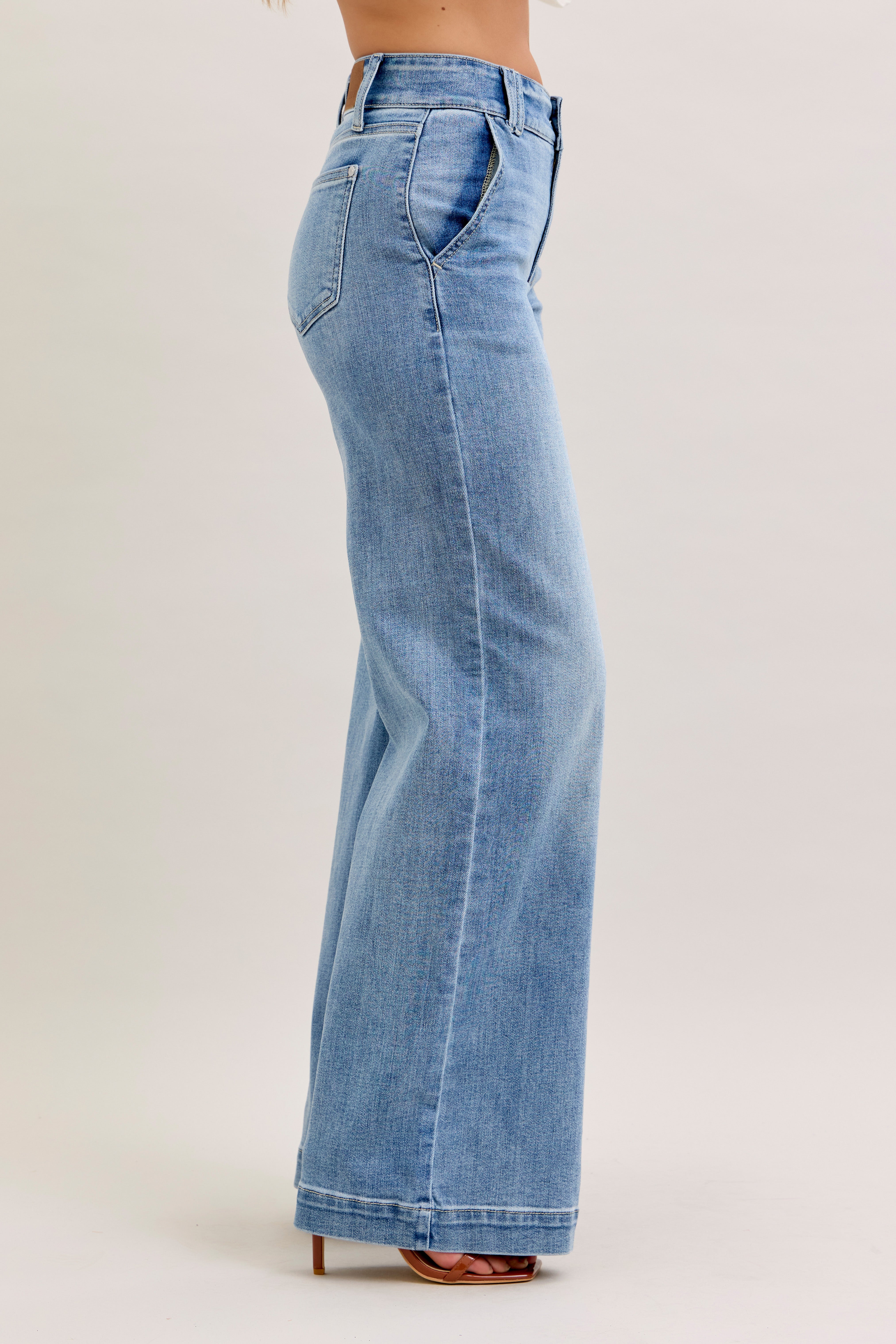 Light blue jeans worn by a person on a plain background