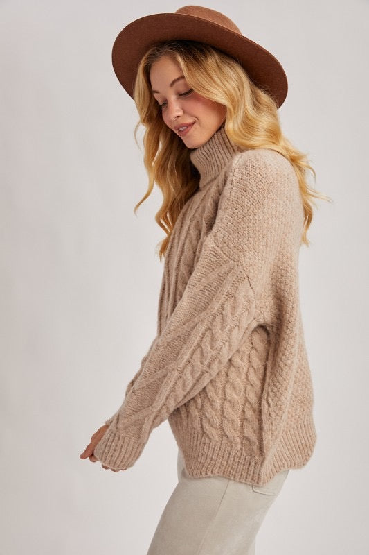 Woman wearing a beige knitted sweater and brown hat on a white background