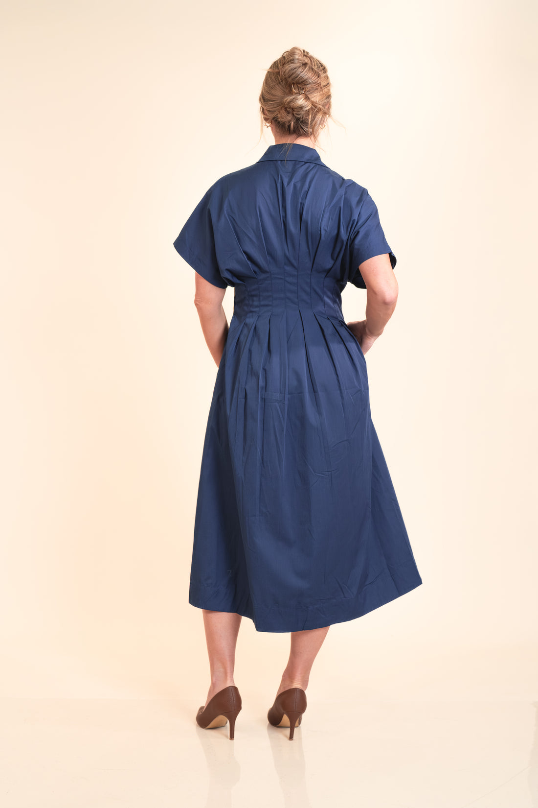 Woman wearing a blue dress on a beige background