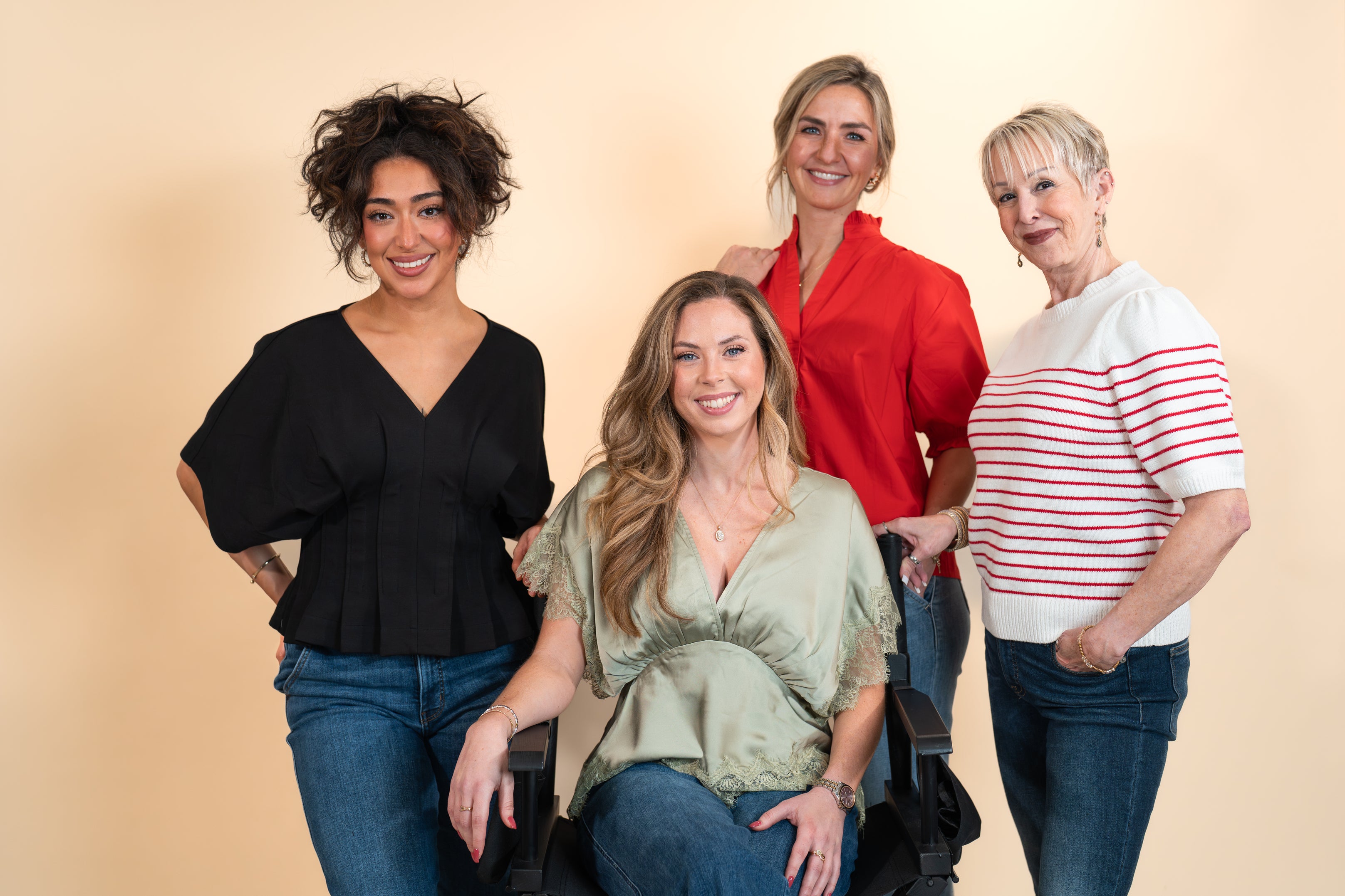 Four women posing together against a beige backgroundslider_item_WM6LcD