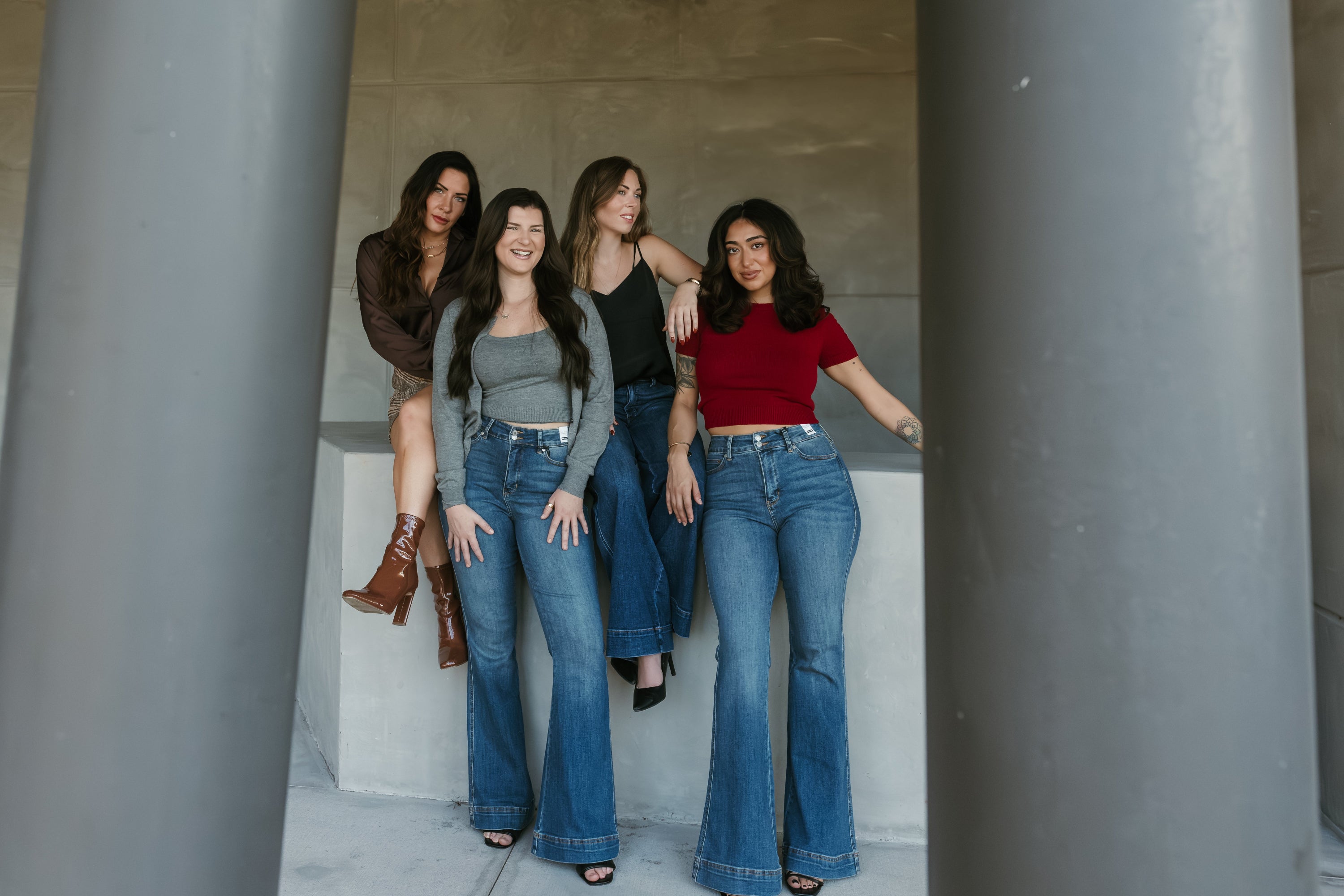 Four women posing together in a modern architectural setting
