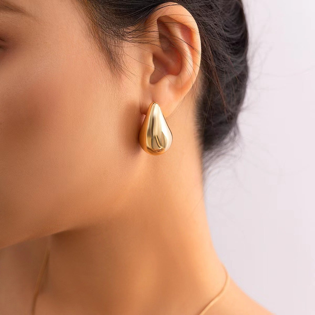 Gold earrings on a brown background