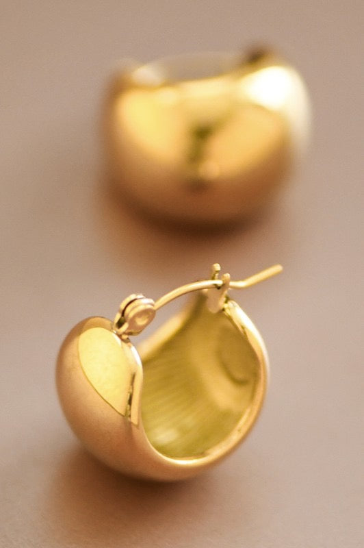Gold hoop earrings on a beige background