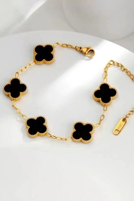 Colorful flower-shaped jewelry on a person's wrist against a neutral background